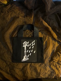 a black tote bag with a drawing on it
