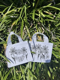 two white tote bags with flowers on them